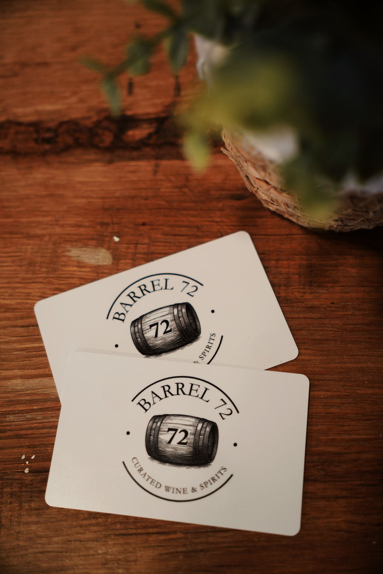 Two Barrel 72 gift cards with the barrel logo resting on a wooden counter