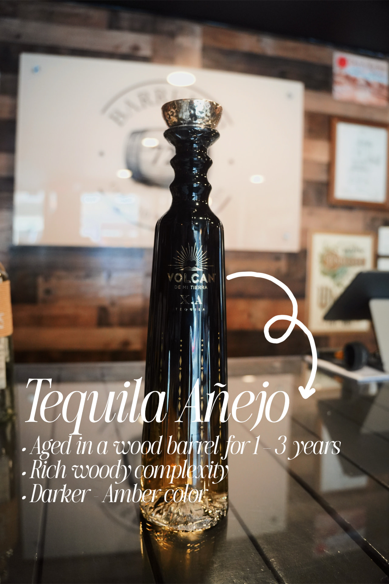A tall dark bottle of añejo tequila with a note explaining añejo is aged one to three years